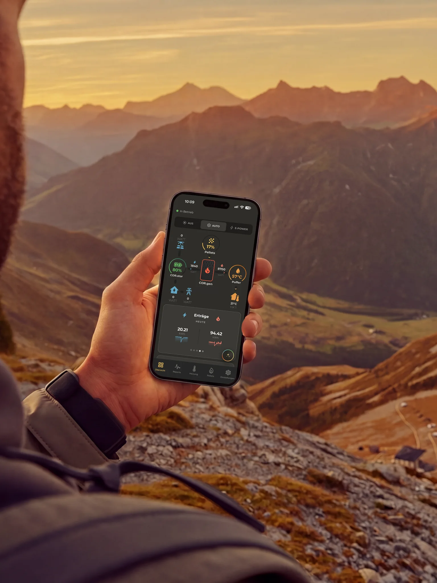 Hand holding a smartphone in front of a mountain landscape, COR.app on the display