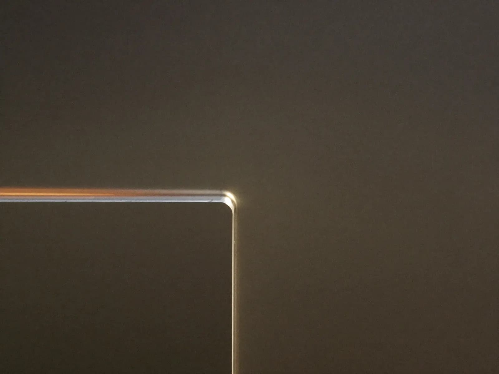 Glühende Lichtkante an einem dunklen Präzisionsgehäuse